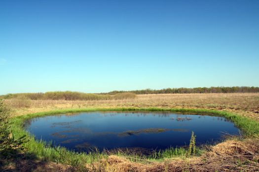 small round lake in steppe