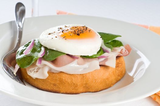 Elegant breakfast sandwich of poached egg and prosciutto.