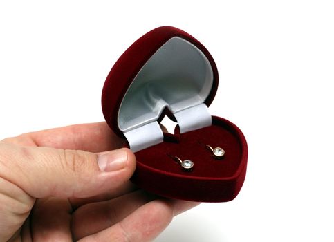 man's hand gifting ear-rings in red box on valentine day isolated on white