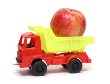 food transportation concept - toy lorry with apple isolated on white