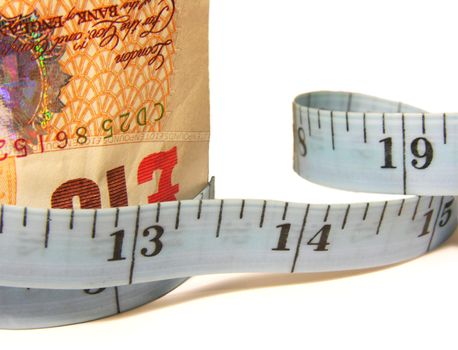 Closeup of a stack of bills encircled by a measuring tape