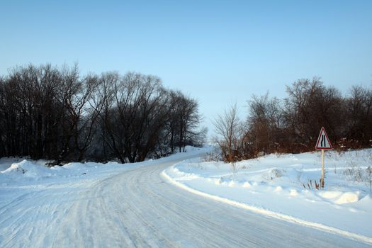 winter snow road with sign in evening