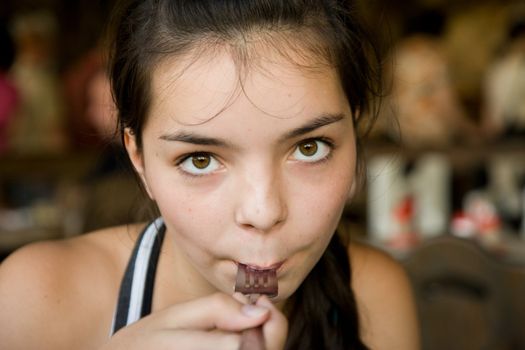 Dark-haired girl-teenager eating in cafe close up
