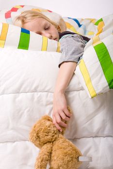 Sleeping young cute child in a colorful bed