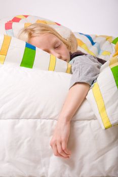 Sleeping young cute child in a colorful bed