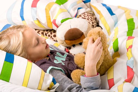 Sleeping young cute child in a colorful bed