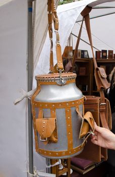 churn upholstered in brown leather straps, pockets and long handle with rivets