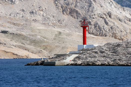 Red see light on island with mountain background.