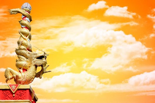 Dragon statue roll the column with sunset sky background