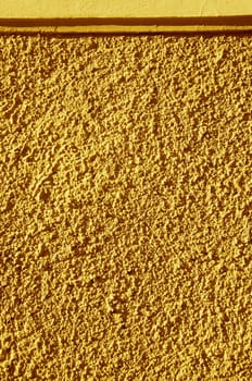 Yellow-painted textured walls macro closeup. Architectural background details.