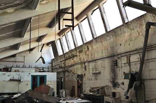 Vandalized equipment and decaying interior of an abandoned factory.