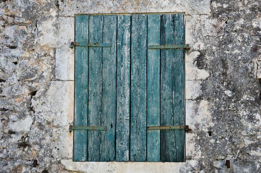 Stone wall and blue window shutter. Traditional house in Zakynthos, Greece.