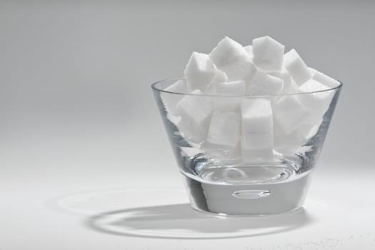 Glass bowl filled with sugar cubes.
