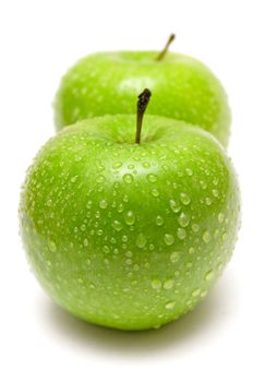 Two wet green apples isolated on a white background.