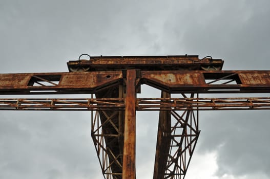 Rusty industrial gantry at abandoned marble processing factory.