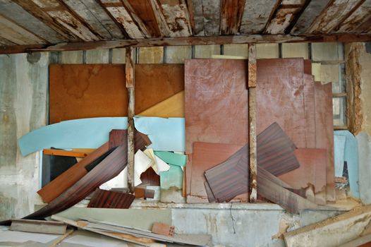 Window boarded up with broken wood planks. Abandoned factory interior.