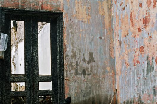 Burned house interior. Vacant room charred door and textured wall.