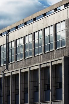 Close-up on industrial, modern building. Glass, concrete and sky.