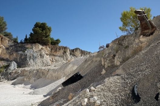 Rusty industrial machinery buried in the sand. Gravel quarry.