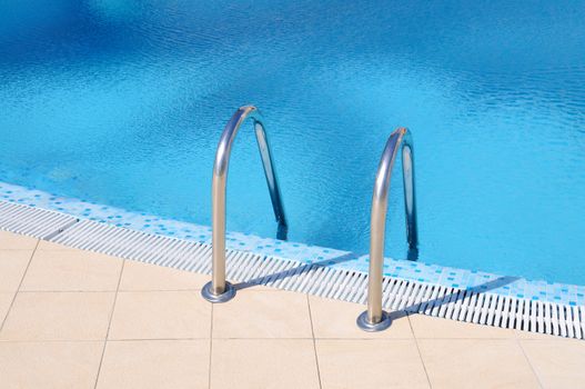 Swimming pool with stairs at hotel close up