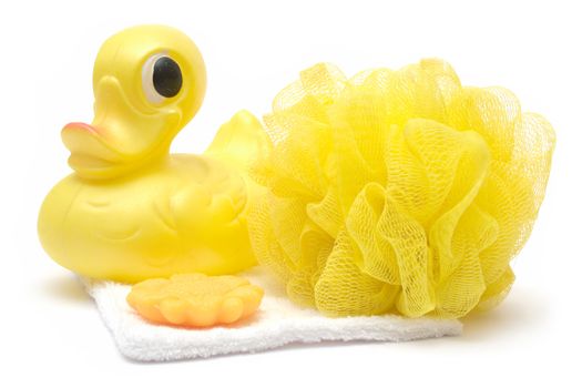 Rubber duck, sponge, soap and folded towel isolated on a white background.