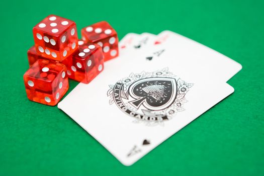 Red Dice and aces isolated on green poker table felt.