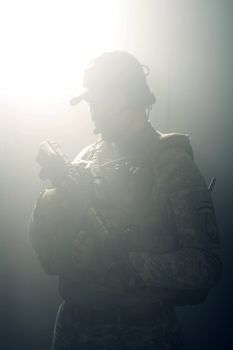 A silhouette of a soldier in the smoke after the explosion