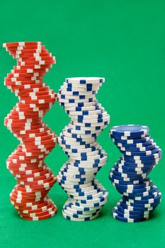 Stacked jetons isolated on green poker table felt.