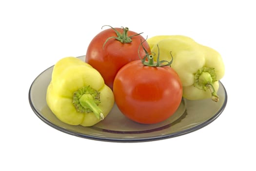 Tomatoes and bell peppers on a plate isolated on white background