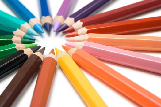 Colorful crayons forming a circle. Isolated on a white background.