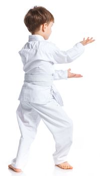 Aikido boy fighting position in white kimono isolated on white