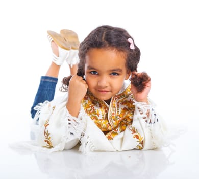 Cute little mulatto girl lying and smiling. Isolated on white background