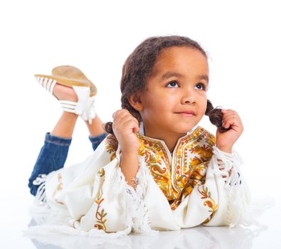 Cute little mulatto girl lying and smiling. Isolated on white background