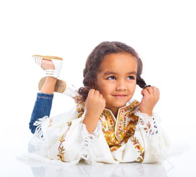 Cute little mulatto girl lying and smiling. Isolated on white background