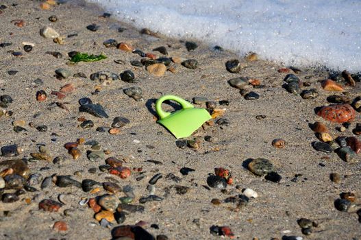 The broken coffee cup on the seacoast, thrown out by a wave