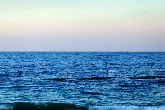 blue sea, the horizon, a iridescent sky, ship on the horizon
