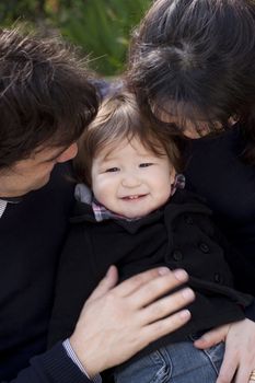 Close up of a little boy surrounded by his parents. Slight blur applied