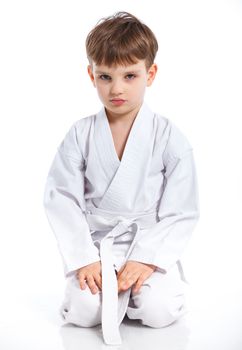 Aikido boy recreation position in white kimono isolated on white