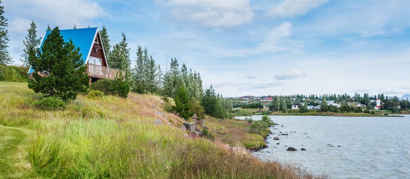 Rural beautiful summer landscape - fjord, house, mountains. Iceland. Panorama.