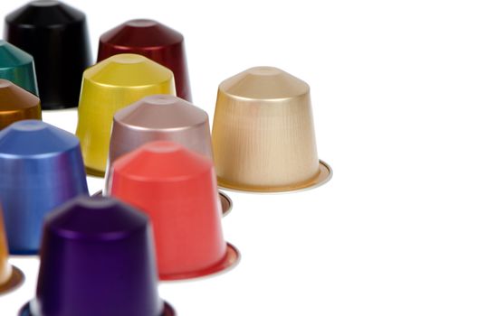 Coffee capsules for a coffee machine, close up view on white reflective background.