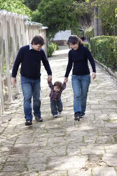 A mixed race family with asian mother and caucasian father, teaching their son to walk
