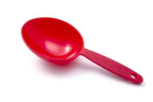 Red measuring spoon closeup on white background 