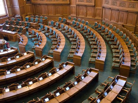 Interior of a parliament senate hall full of seats and work desks