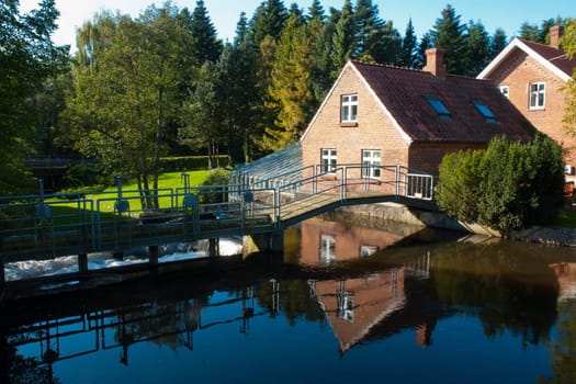 Beautiful traditional countryside style house reflected in a lake Denmark