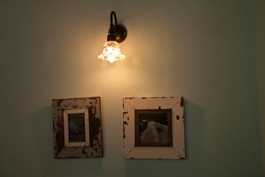 Vintage elegant wall lamp hanged above antique pictures