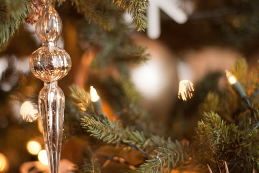 gold glass ornament hanging on a Christmas tree