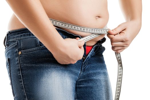 Overweight woman wearing jeans measuring her fat body belly paunch