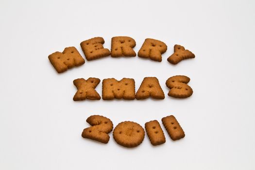 Merry Xmas 2011 wording from brown biscuits at center frame on white background  in landscape orientation