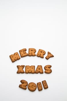 Merry Xmas 2011 wording from brown biscuits at lower center frame on white background  in portrait orientation