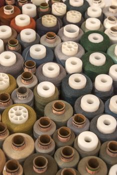 Different colored threads reels from above view as background